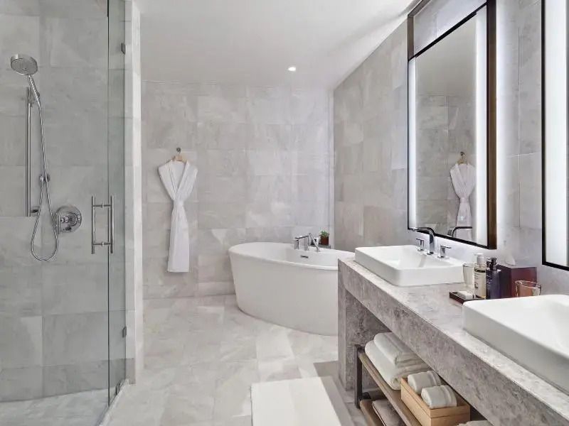 Luxuriöses Badezimmer mit begehbarer Dusche und freistehender Badewanne in Marmoroptik