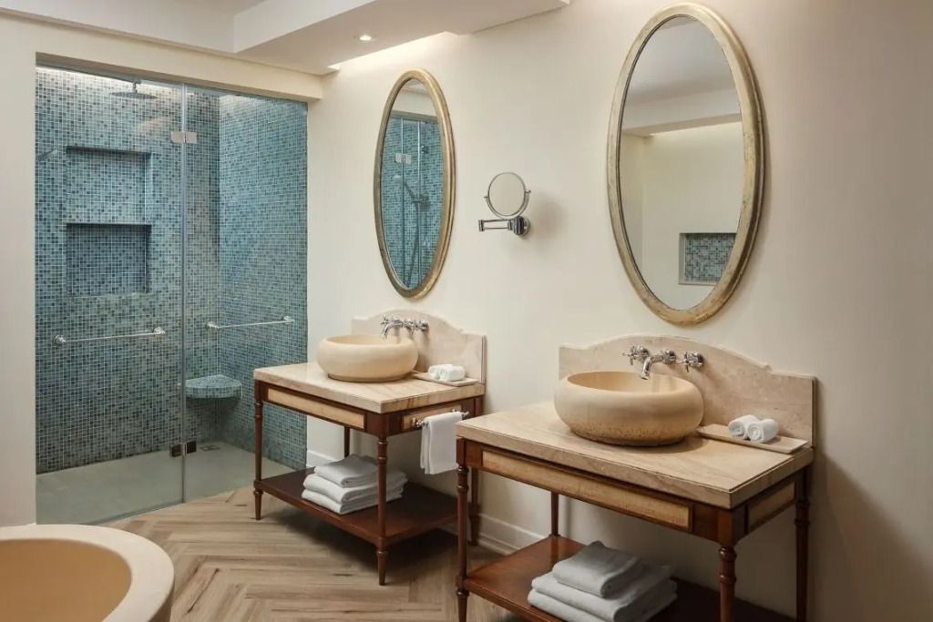 Luxuriöses Badezimmer der Junior-Suite mit Doppelwaschbecken und großen Spiegeln
