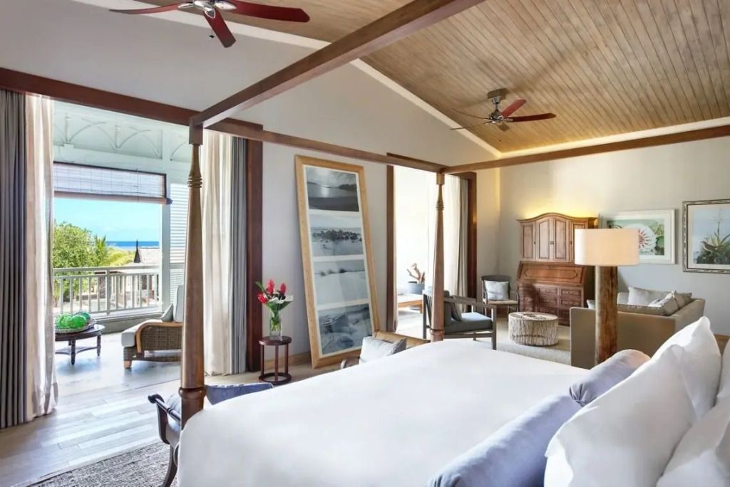 Elegantes Schlafzimmer mit Himmelbett und Balkon mit Meerblick