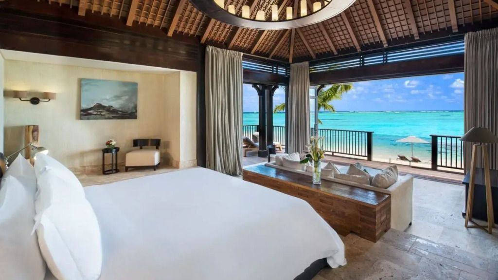 Helles Schlafzimmer mit Meerblick und Holzdach in einer luxuriösen Villa.