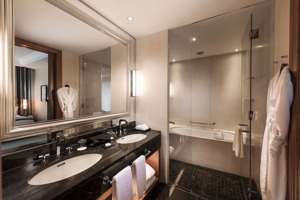 Modernes Badezimmer mit Doppelwaschbecken und Badewanne im Hotelzimmer