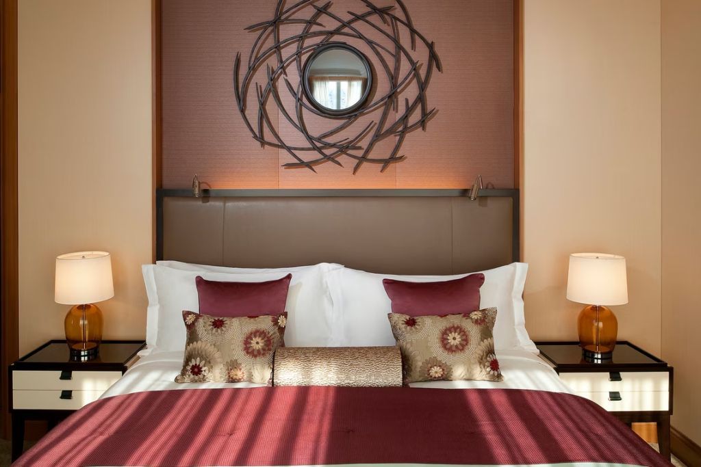 Elegantes Bett mit dekorativen Kissen und Wandkunst im St. Regis Osaka.