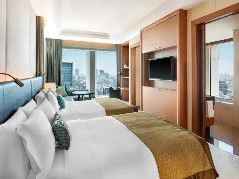 Helles Doppelzimmer mit zwei Einzelbetten und großer Fensterfront im St. Regis Osaka.