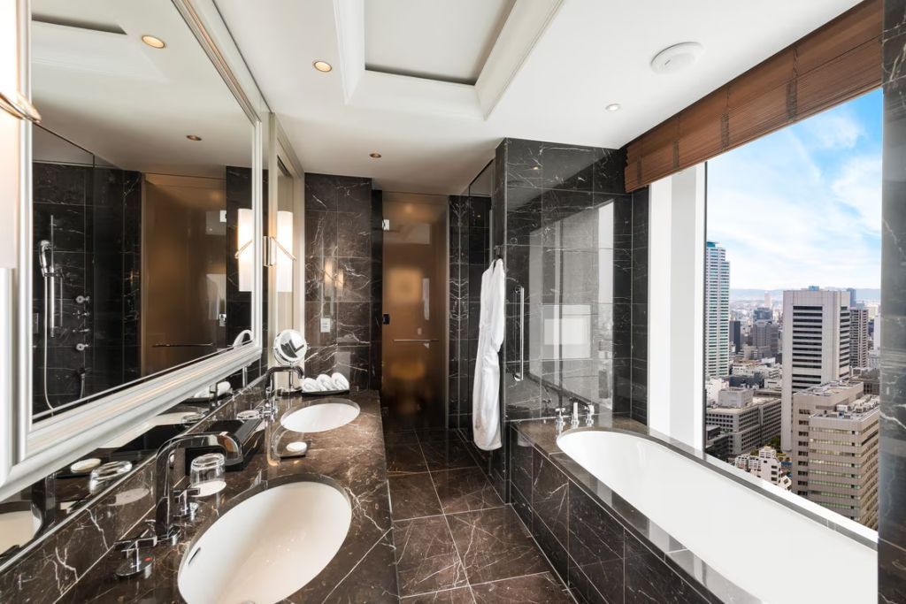 Modernes Badezimmer mit Marmor und Panoramaausblick in der Suite.