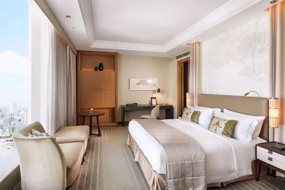 Helles Hotelzimmer mit Doppelbett und Arbeitsbereich