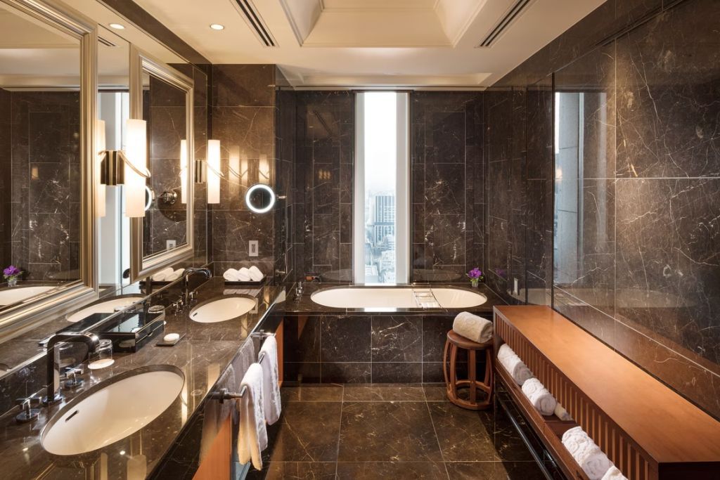 Luxuriöses Badezimmer mit Marmorverkleidung und freistehender Badewanne
