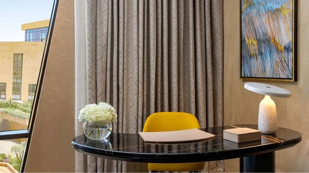 Schreibtisch mit gelbem Stuhl und Blumendekoration im Zimmer.