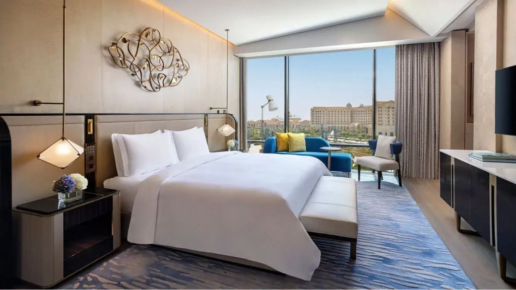 St. Regis Suite mit Doppelbett und Panoramablick auf die Stadt durch bodentiefe Fenster
