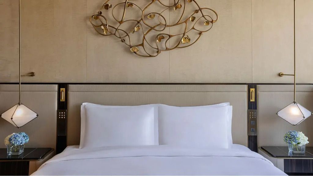 Detailansicht des Doppelbetts in der St. Regis Suite mit kunstvollem Wandrelief