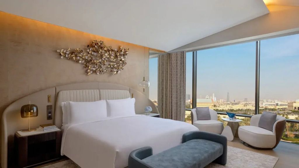 Luxuriöses Schlafzimmer mit großem Doppelbett und Panoramablick auf die Stadt.