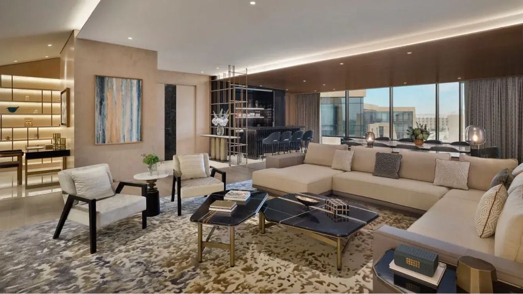 Großzügiges Wohnzimmer mit luxuriöser Einrichtung und großen Fenstern.
