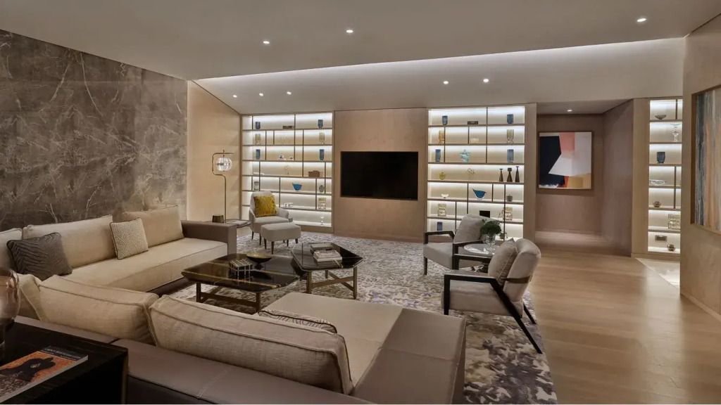 Schickes Wohnzimmer mit elegantem Sofa und großer Bücherwand.