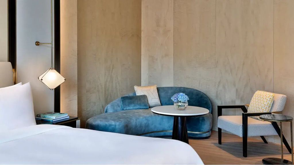 Stilvolle Sitzecke mit blauer Couch und Blumen im St. Regis Riyadh.