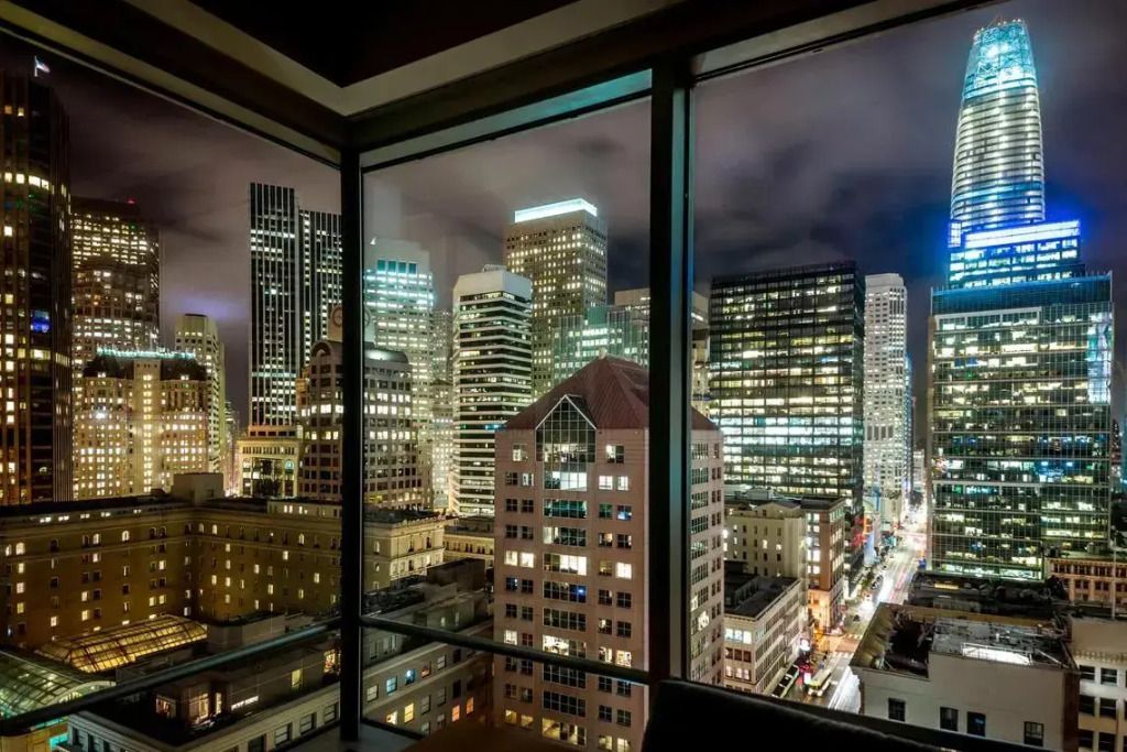 Nächtliche Aussicht auf die erleuchtete Skyline von San Francisco aus einem Zimmer