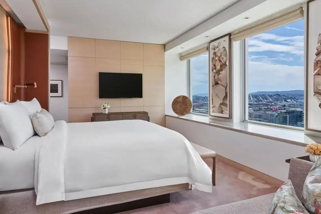 Helles Schlafzimmer mit großem Fenster in der Präsidentensuite mit Blick über die Stadt.