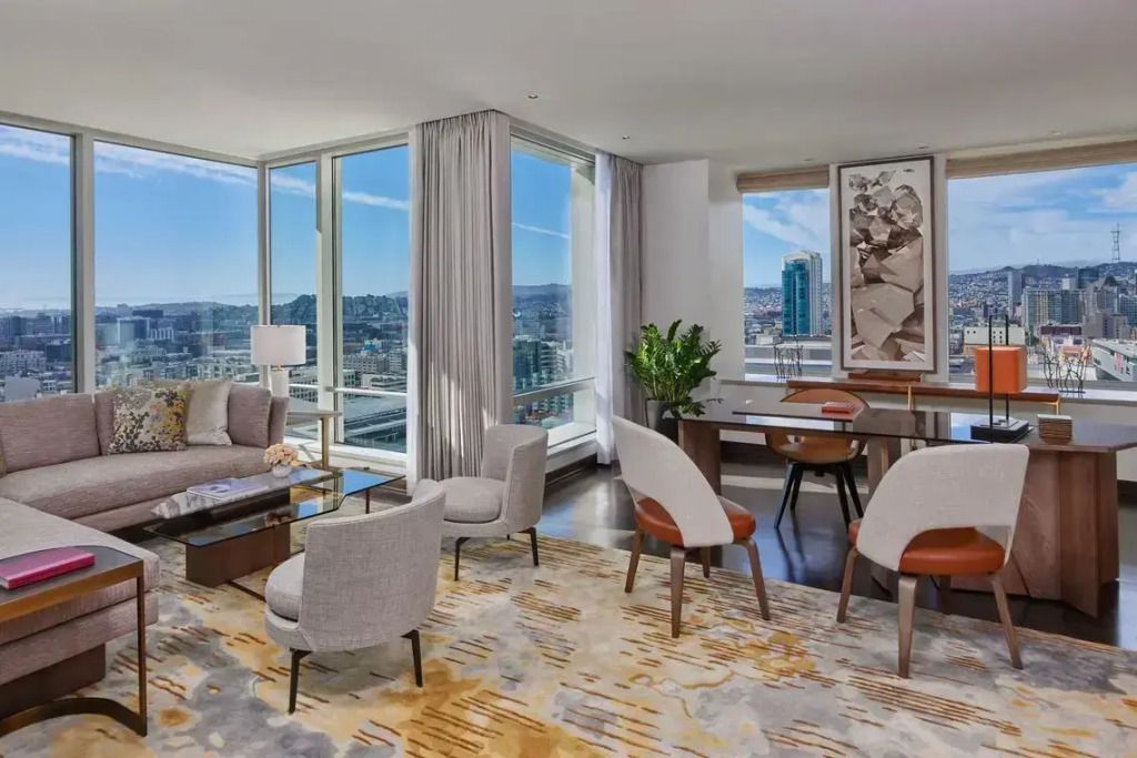 Weitläufiger Wohnbereich in der Präsidentensuite mit Arbeitsecke und großen Fenstern.