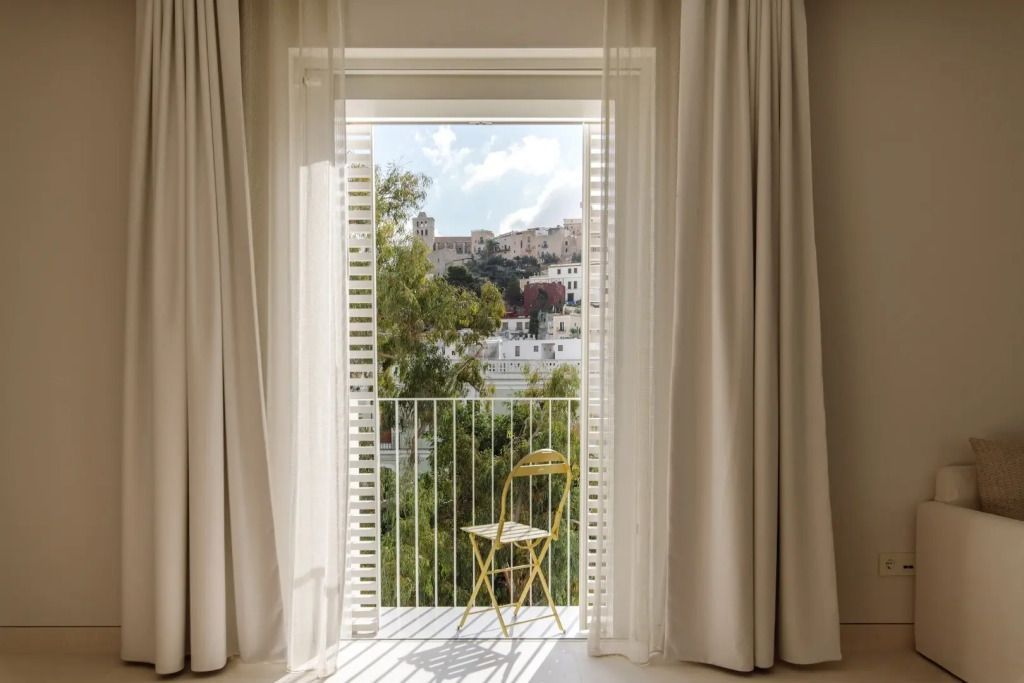 Balkonaussicht mit Klappstuhl und Blick auf die Altstadt von Ibiza.