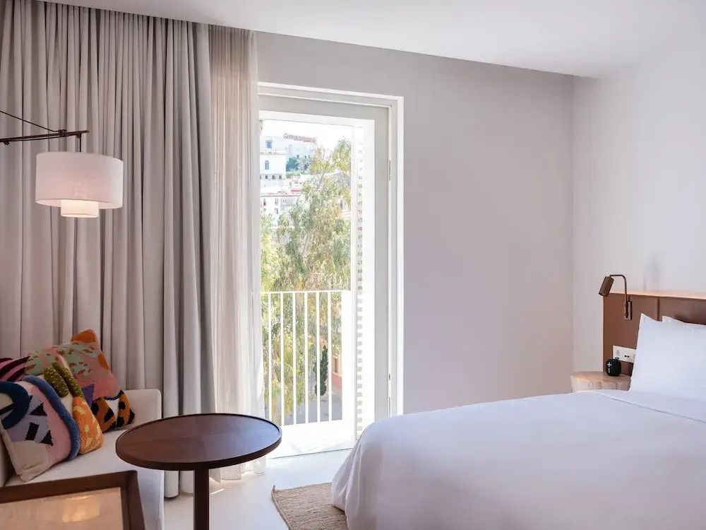 Geräumiges Deluxe Doppelzimmer mit großen Fenstern und Balkon.