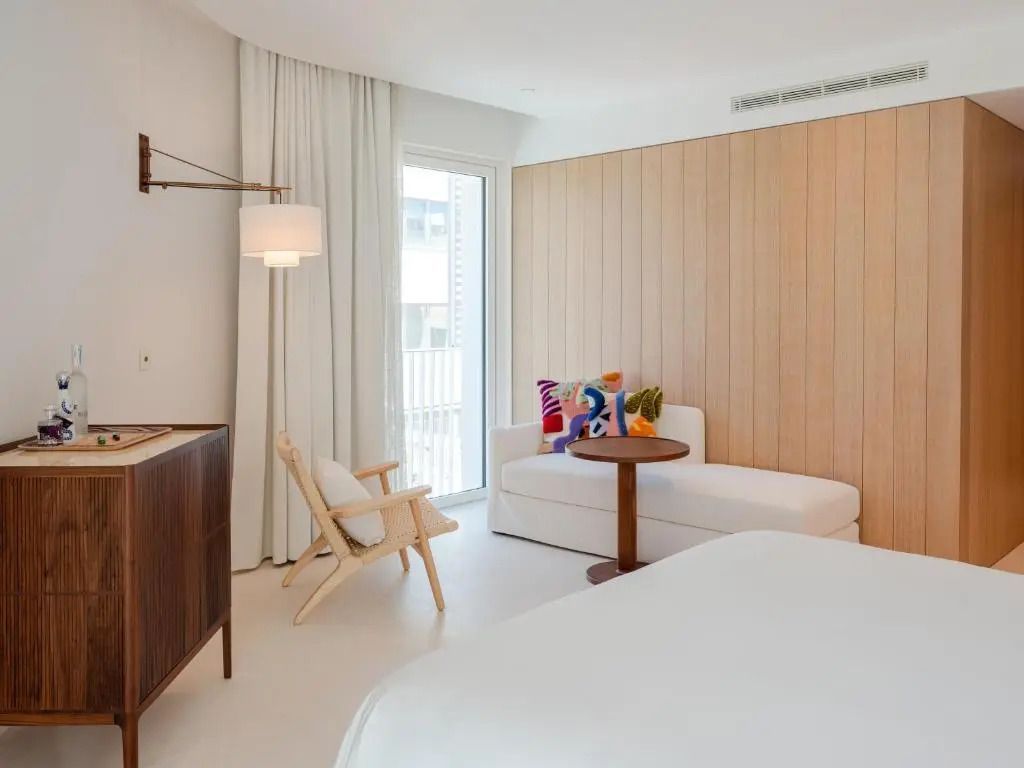Elegantes Hotelzimmer mit Holzwand, Sesseln und Fenster im Standard Ibiza