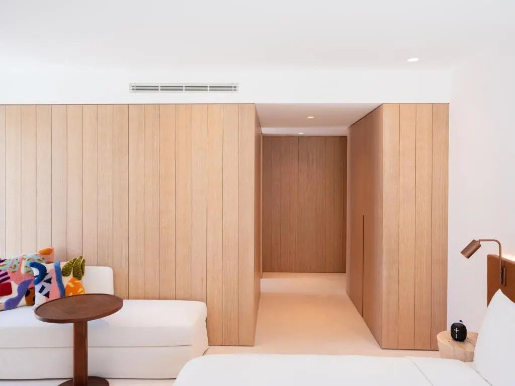 Geräumiger Bereich mit Holzverkleidung und modernem Stil im Hotelzimmer