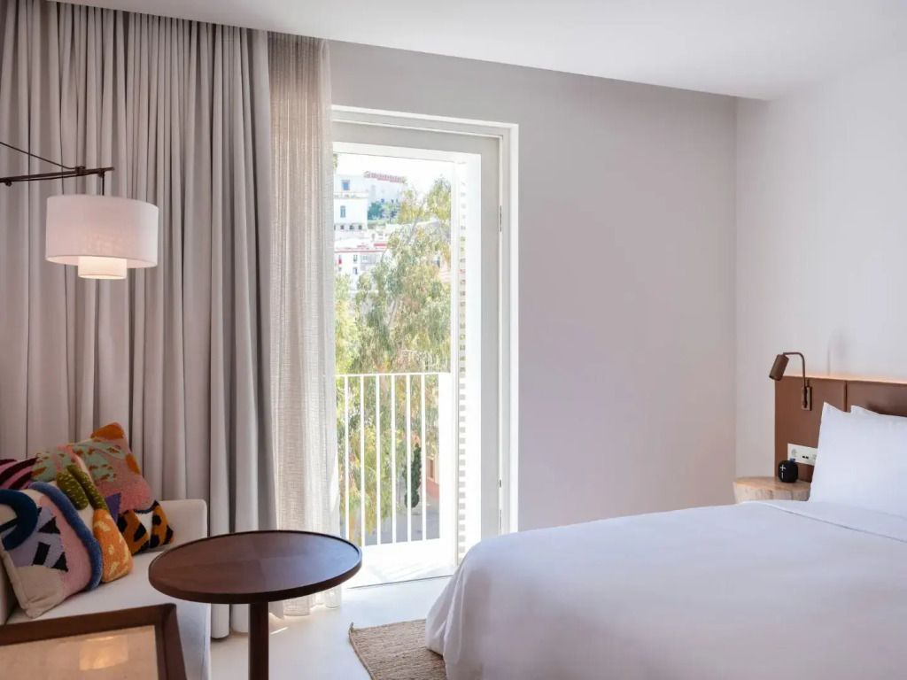 Modernes Doppelzimmer mit hellem Dekor und Blick auf den Balkon