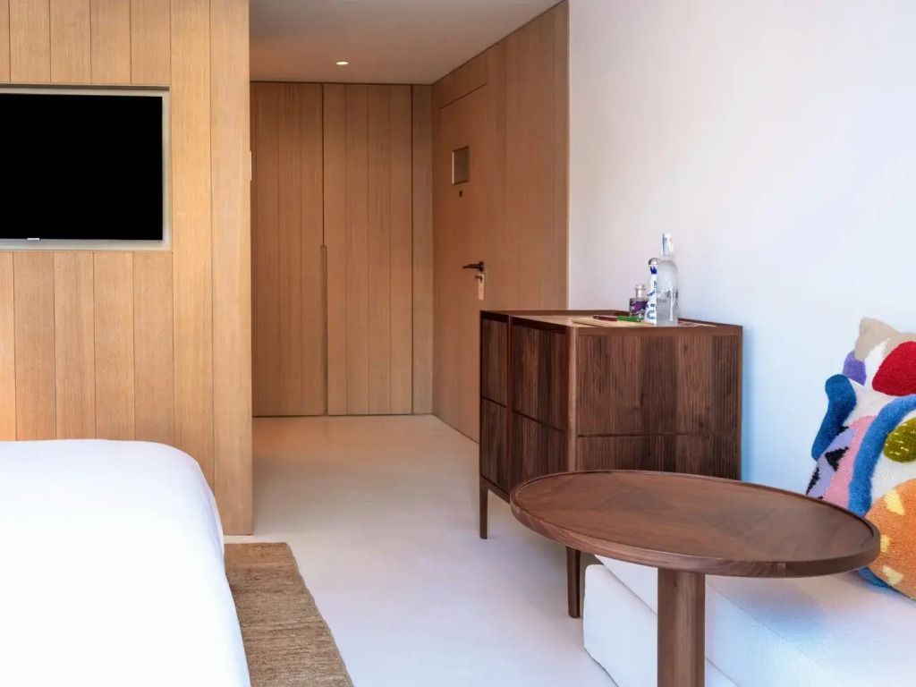 Elegant eingerichtetes Doppelzimmer mit Holzmöbeln und minimalistischer Gestaltung