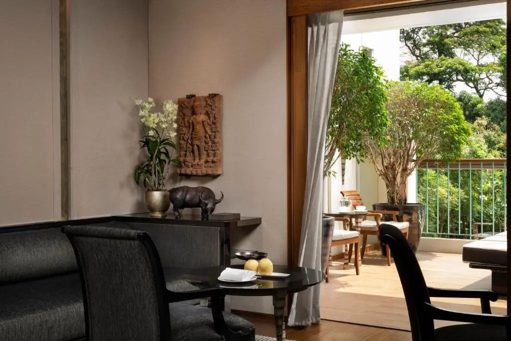 Zimmer mit Sitzecke und Terrasse mit Pflanzen im The Sukhothai Bangkok