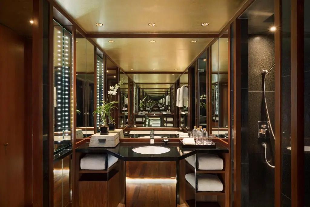 Luxuriöses Badezimmer mit Spiegelwänden und moderner Ausstattung.
