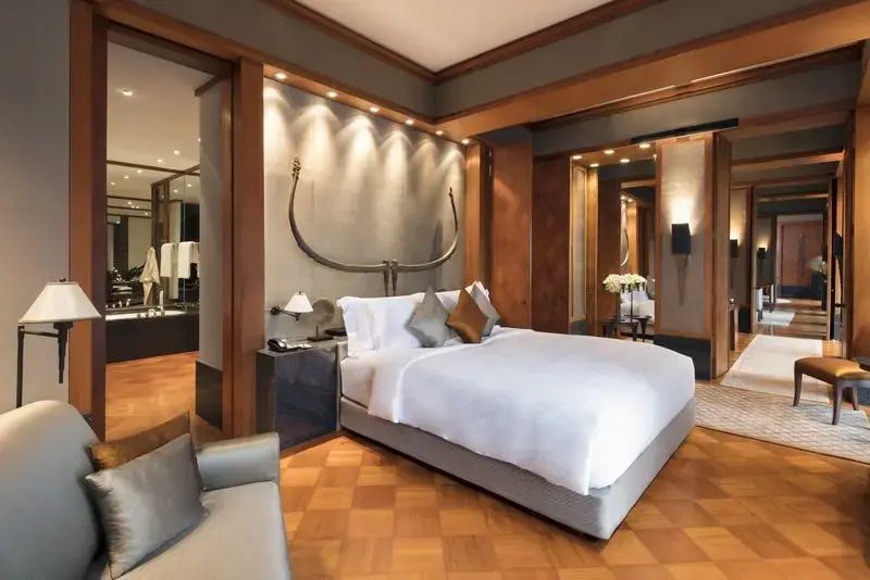Luxuriöses Schlafzimmer der Sukhothai Suite mit elegantem Dekor und Holzakzenten