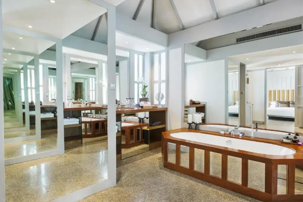 Geräumiges Badezimmer mit eleganter Badewanne und dekorativen Spiegeln