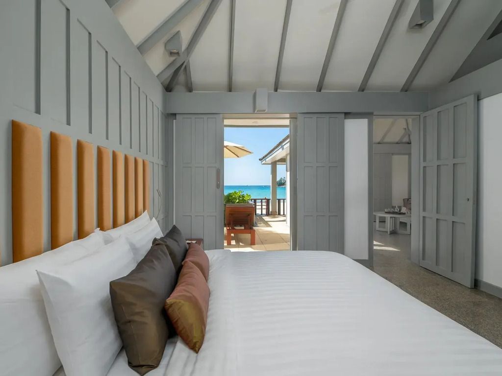 Gemütliches Schlafzimmer mit Meerblick und geöffneter Tür zur Terrasse.