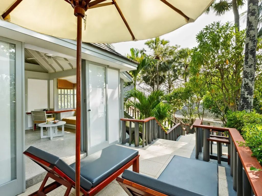 Private Terrasse mit Liegestühlen und grünem Ausblick im Surin Phuket