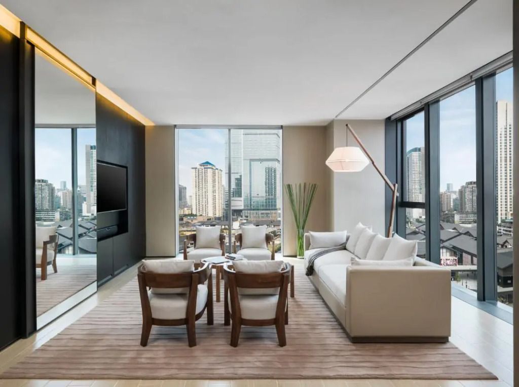 Modernes Wohnzimmer mit Stadtblick und stilvollen Möbeln im Upper House Chengdu.