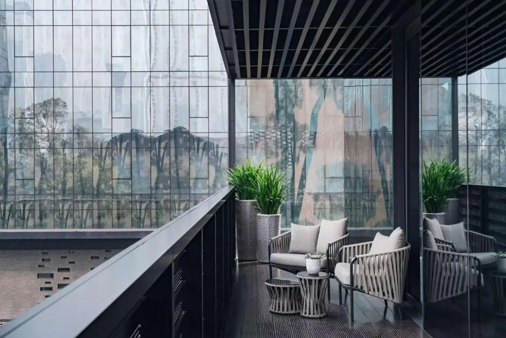 Eleganter Balkon mit Sitzmöbeln und Blick auf moderne Hochhäuser.