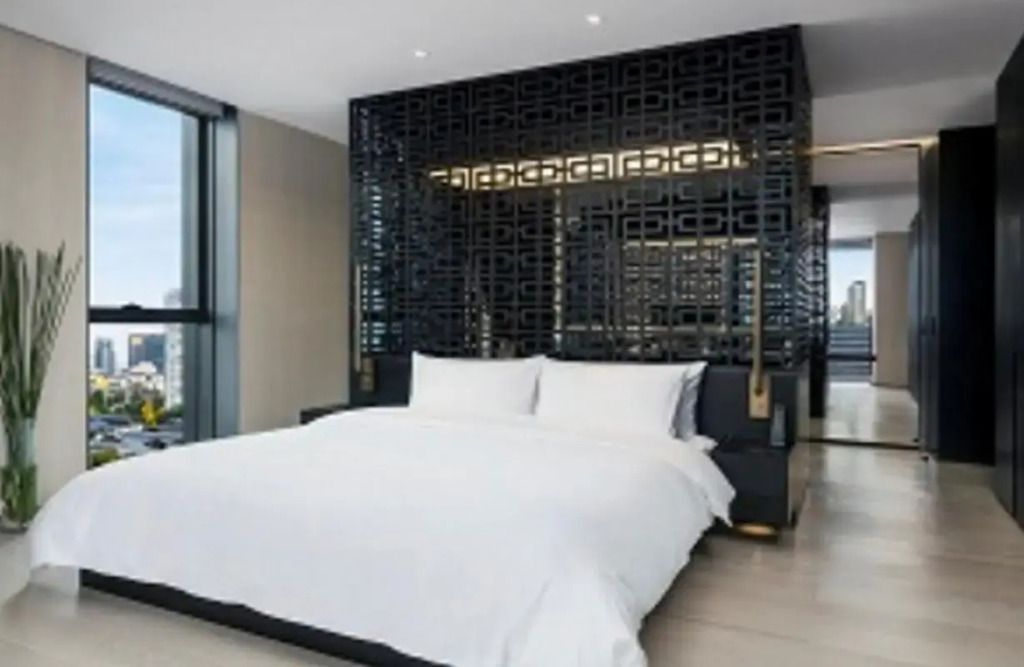 Schlafzimmer mit großem Bett und aufwendigem Wanddesign in schwarz-gold