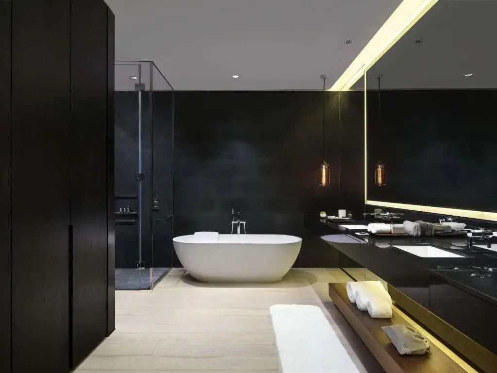 Luxuriöses Badezimmer mit freistehender Badewanne und dunklem Dekor