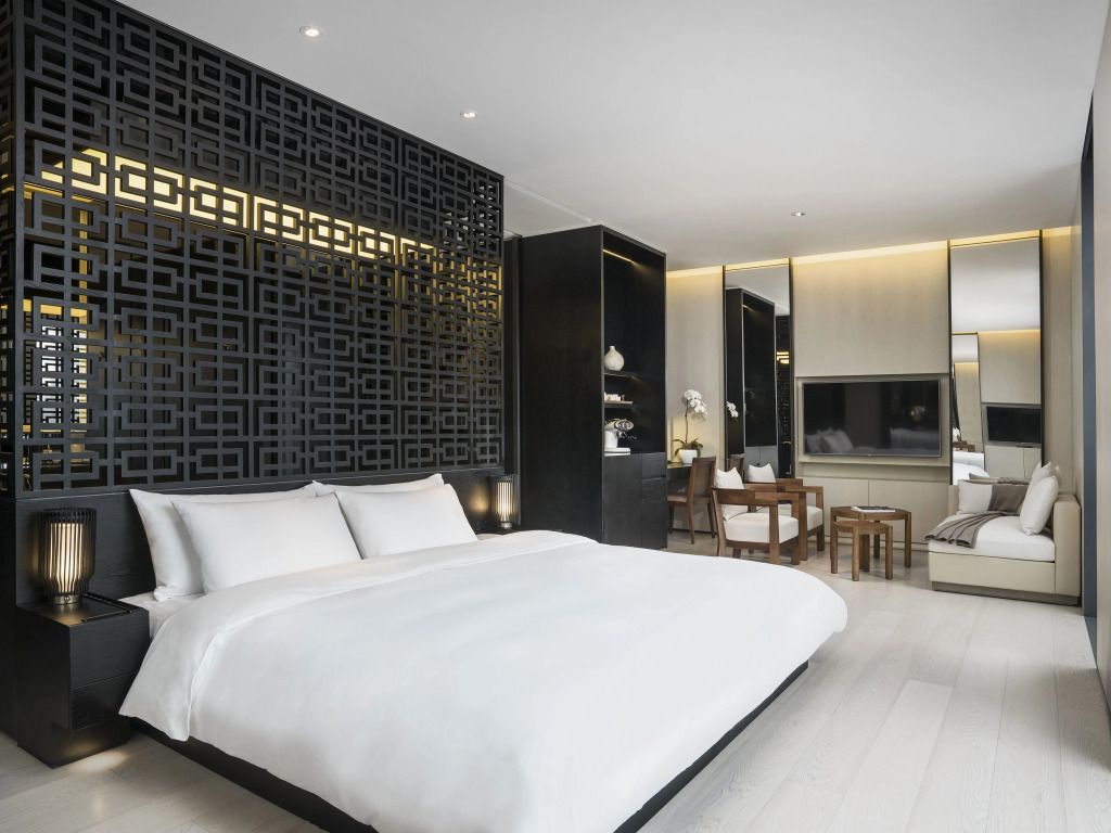 Modernes Hotelzimmer mit elegantem schwarz-weißem Design und großer Spiegelwand.
