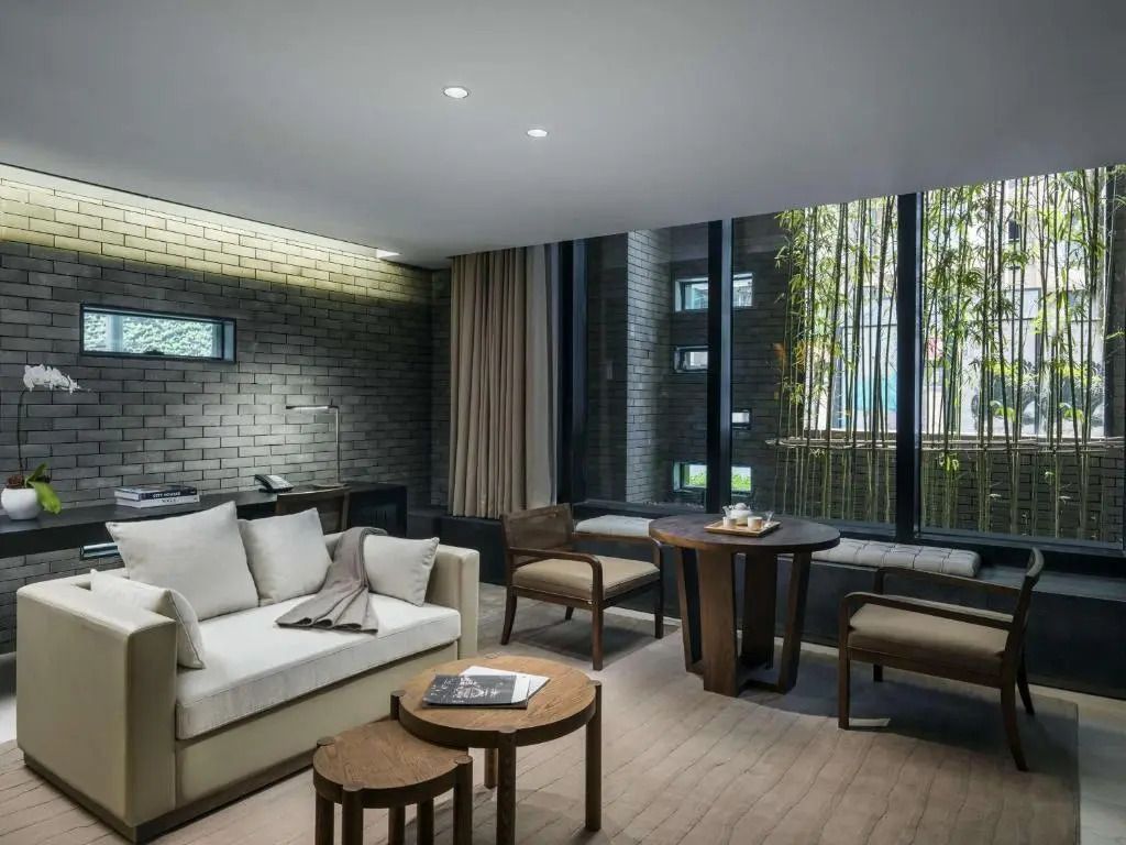Luxuriöser Wohnbereich mit Sofa, Tisch und Blick auf Bambuspflanzung