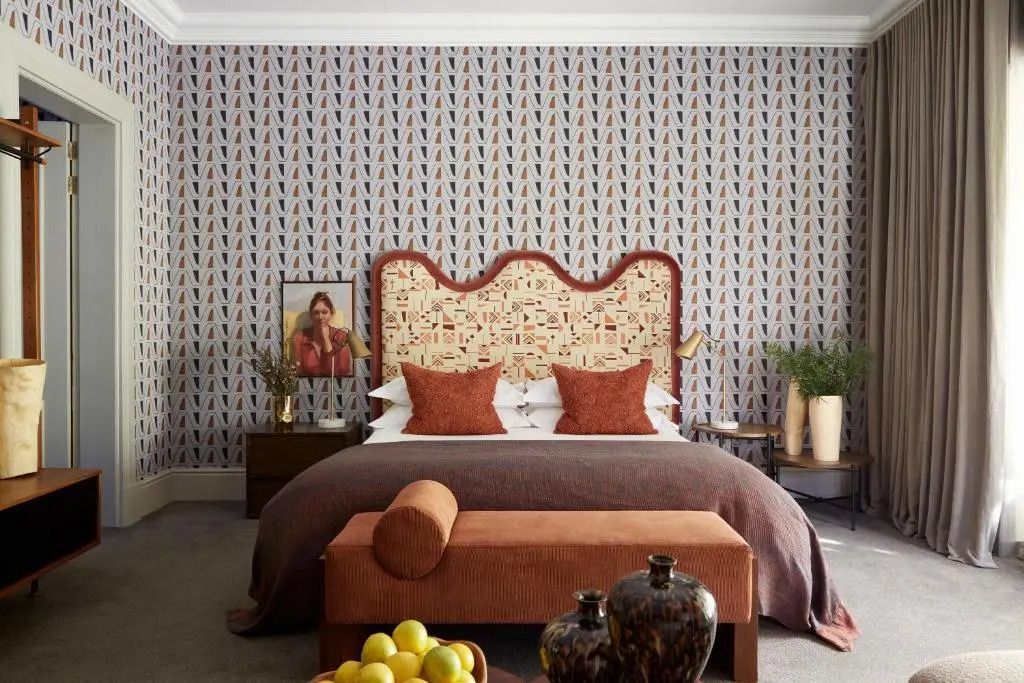 Elegantes Schlafzimmer mit Kopfteil und gemusterten Wänden