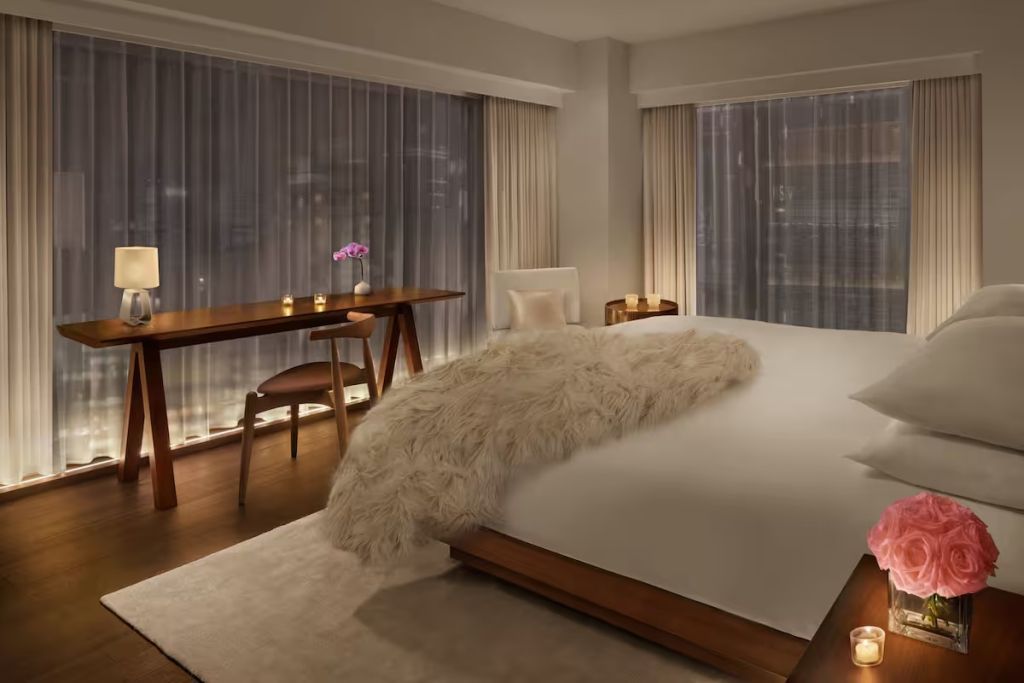 Elegantes Schlafzimmer in neutralen Tönen mit großem Bett und luxuriöser Beleuchtung.