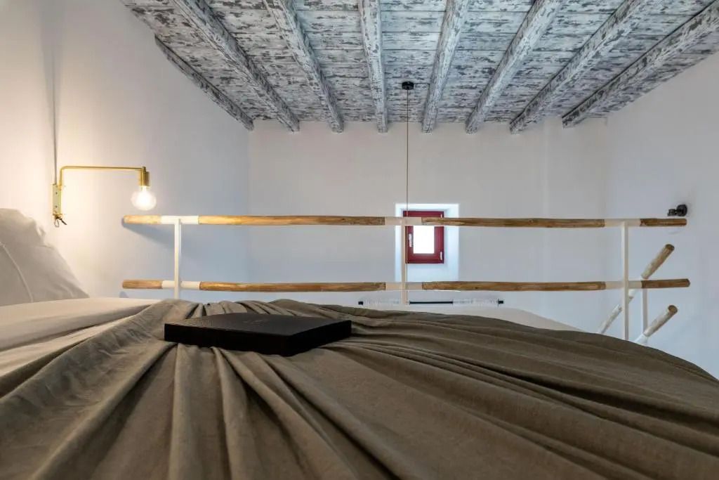 Detailansicht eines Schlafbereichs mit Holzgeländer und sichtbaren Holzbalken