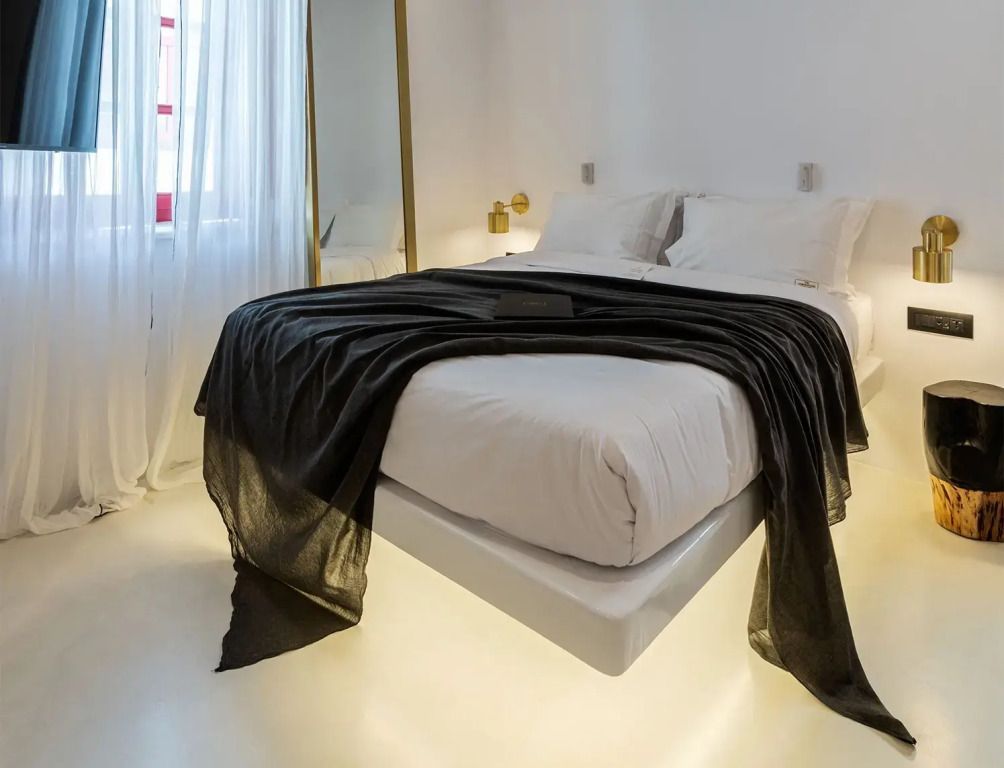 Minimalistisch eingerichtetes Schlafzimmer mit großzügigem Doppelbett und stilvoller Dekoration.