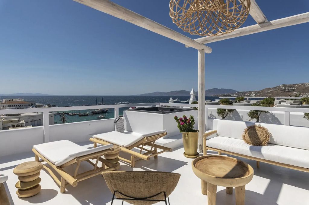 Terrasse mit Sonnenliegen und Blick auf das Meer und die Stadt