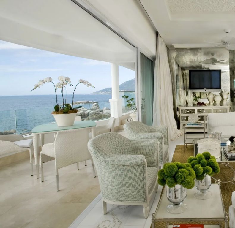 Helle Lounge mit Meerblick und moderner Einrichtung auf einer Terrasse