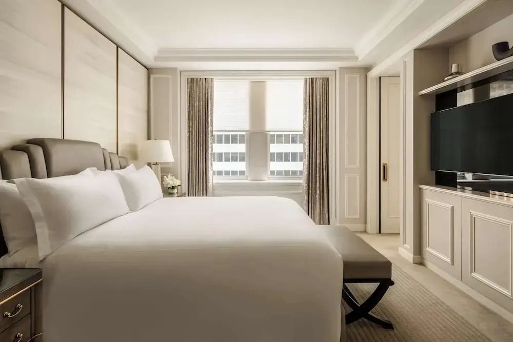 Luxuriöses Schlafzimmer mit Kingsize-Bett, eleganten Vorhängen und Stadtblick