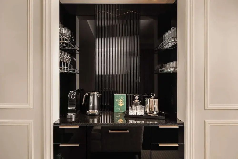 Luxuriöse Minibar mit glänzender schwarzer Oberfläche und hochwertigen Getränken