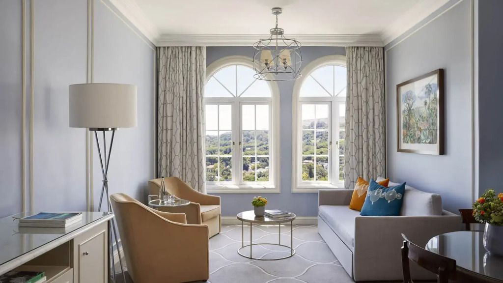 Gemütliches Wohnzimmer mit großen Fenstern und eleganten Sitzmöbeln
