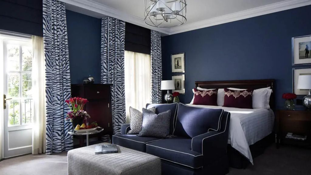 Luxuriöses Zimmer mit dunkelblauer Wandfarbe und eleganter Dekoration