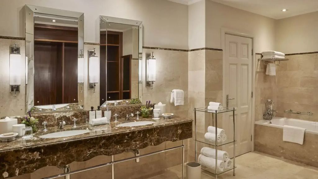Geräumiges Badezimmer mit Doppelwaschbecken, Spiegeln und luxuriöser Ausstattung.