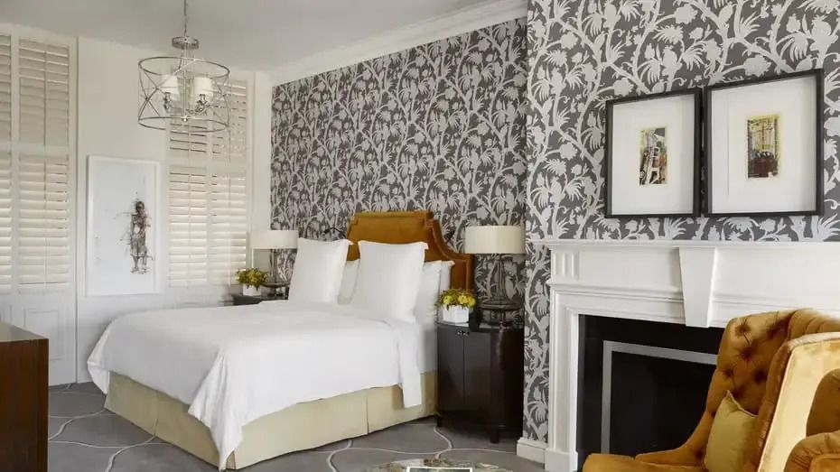Elegantes Schlafzimmer mit gemusterten Tapeten und Kamin in der Royal Suite